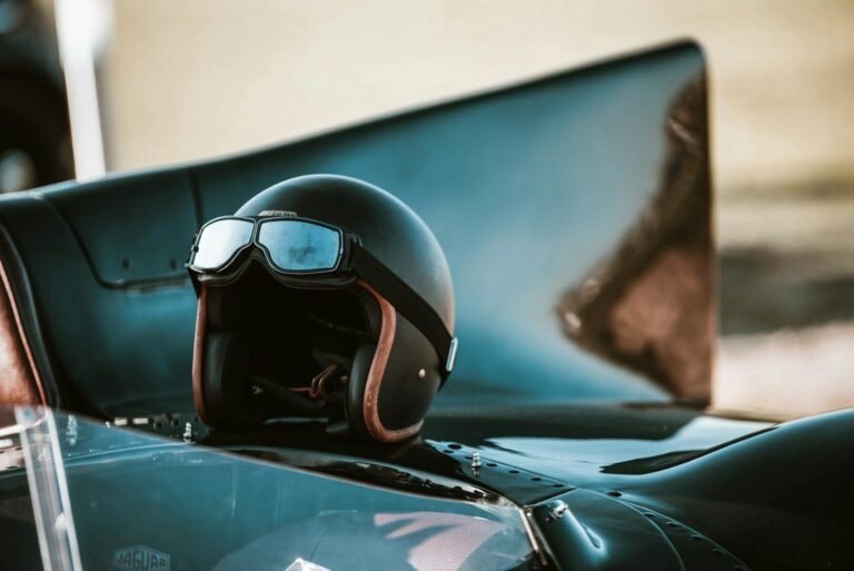 Casco y antiparras vintage sobre un auto de carrera clásico
