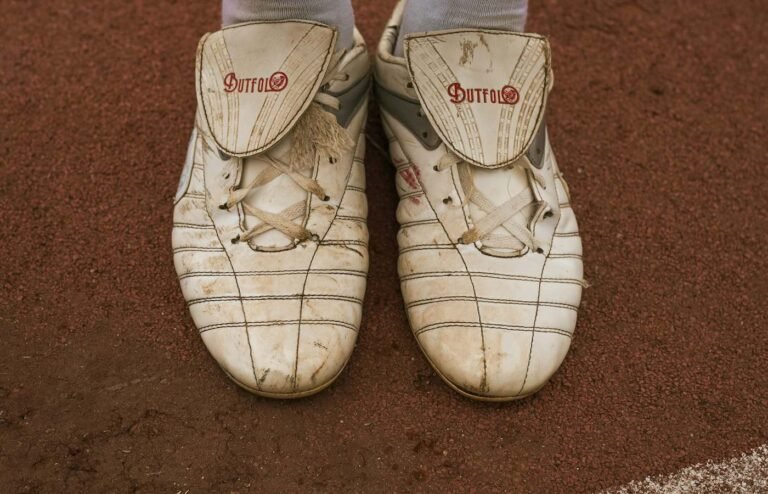 Botines de fútbol gastados sobre polvo de ladrillo