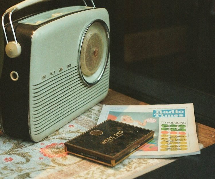 Radio vintage junto a un diario sobre una mesa