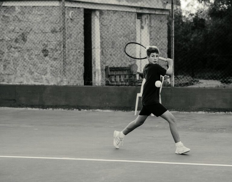 Tenista en blanco y negro golpeando un drive en una cancha de polvo